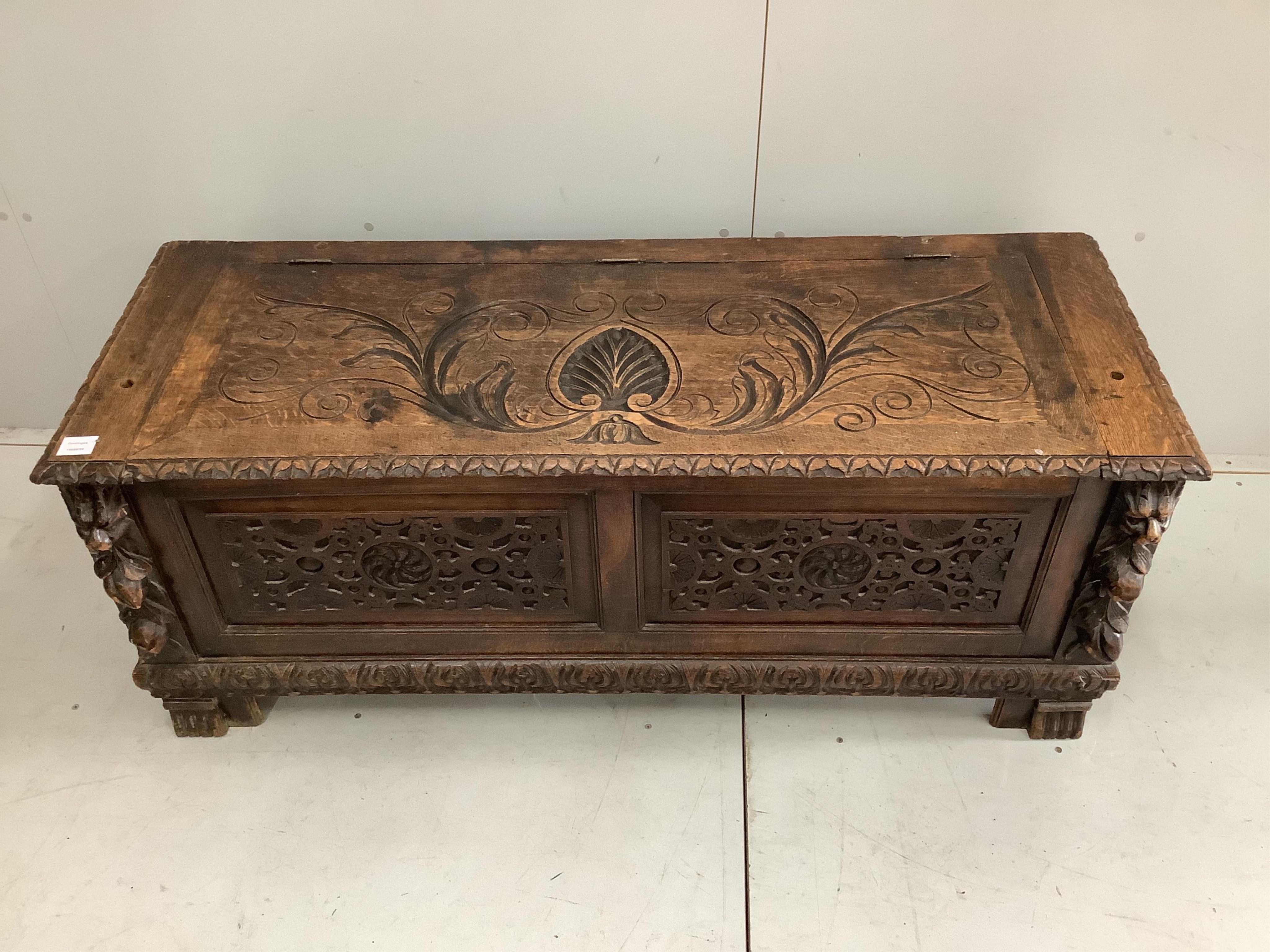 An early 20th century carved oak coffer formerly a monk's bench, width 137cm. Condition - lacking original arms and back, otherwise fair